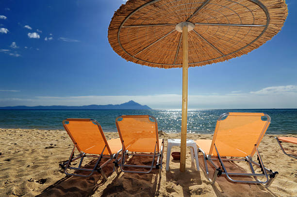 Decks and umbrella on beach  halkidiki beach stock pictures, royalty-free photos & images