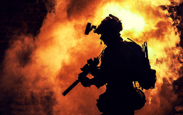 istock Soldier silhouette on background of fire and smoke 1205490711