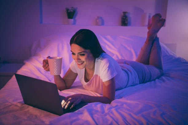 Nice attractive lovely cheerful cheery girl lying on bed using laptop chatting with boyfriend enjoying, rest video contact call communicate online web cam drinking cacao at night room house flat agradable atractiva encantadora chica alegre alegre alegre acostado en la cama usando ordenador portátil charlando con el novio disfrutando de la llamada de contacto de vídeo de descanso comunicaren la cámara web en línea bebiendo cacao en la casa de l