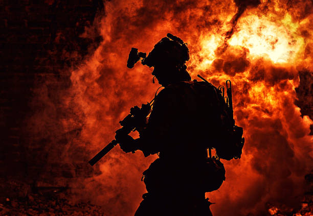 istock Soldier silhouette on background of fire and smoke 1205490738