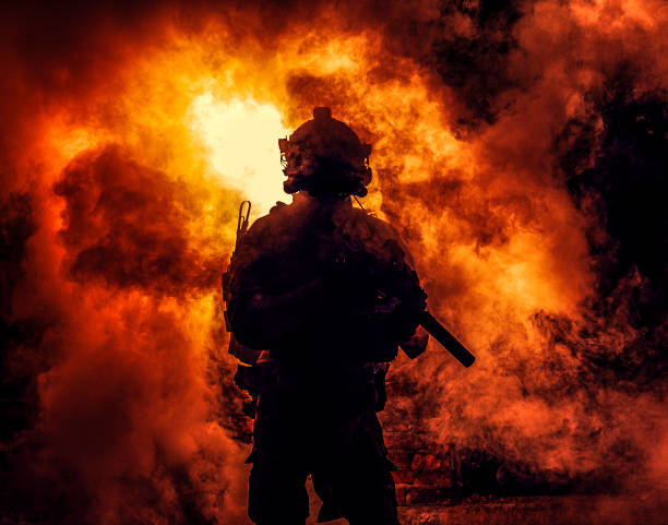 istock Soldier silhouette on background of fire and smoke 1205490759
