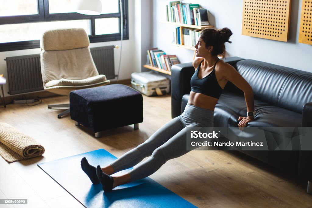 Joven mujer en forma haciendo ejercicio en casa - Foto de stock de Ejercicio físico libre de derechos