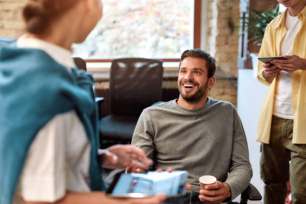istock Lets Take Coffee Break. Happy successful businessman talking with his colleagues and drinking coffee while sitting in the modern office 1205492113