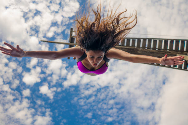 aero yoga workout - young attractive and athletic girl practicing aerial yoga exercise training acrobatic  jump resembling bungee jumping feeling the excitement and emotion of adrenalyn stock photo