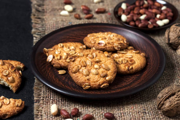istock Homemade peanut cookies on a brown plate with raw peanuts in background 1205492170