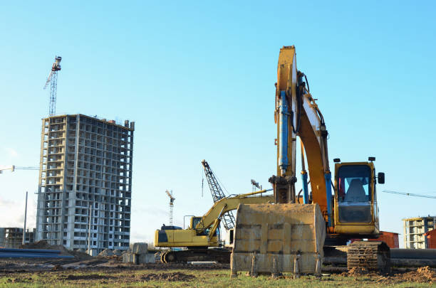 istock Excavator digs ground at a construction site for installing concrete storm pipes 1205492331