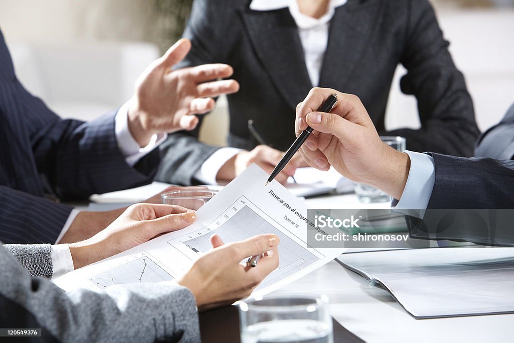 Planning Close-up of businessman explaining a financial plan to colleagues at meeting    Business Stock Photo