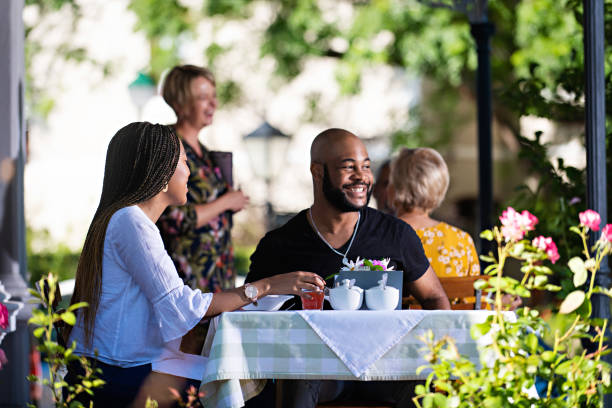 istock Couple on a restaurant veranda having a meal laughing looking away 1205497325