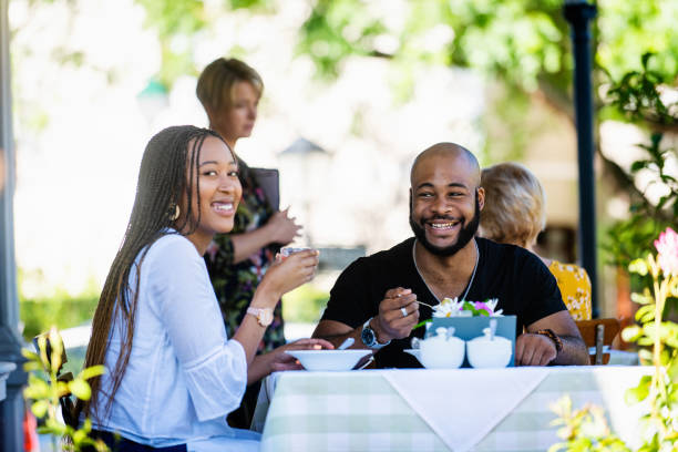 istock Couple on a restaurant veranda having a meal looking at camera 1205497466