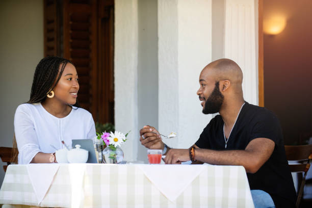 istock Couple on a bed and breakfast porch having a meal talking together 1205497478