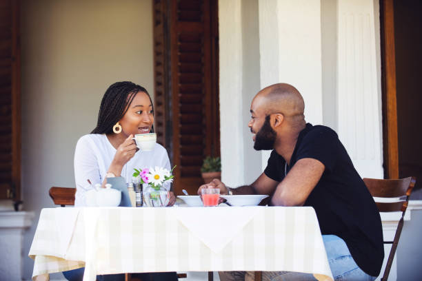 istock Couple on a stoep having a meal together smiling 1205497653