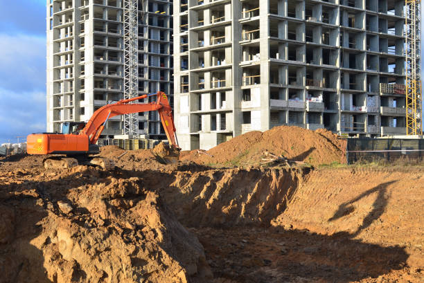 istock Excavator digs ground at a construction site for installing concrete storm pipes 1205499109