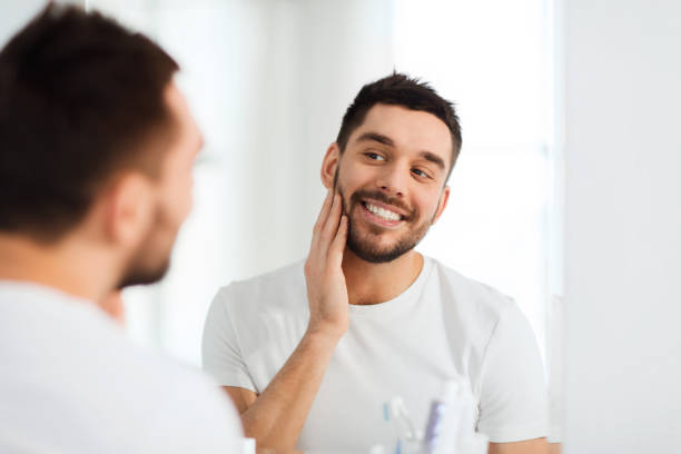 istock happy young man looking to mirror at home bathroom 1205500042