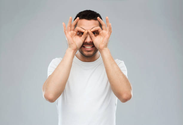 istock man making finger glasses over gray background 1205500592