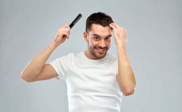 istock happy man brushing hair with comb over gray 1205500896