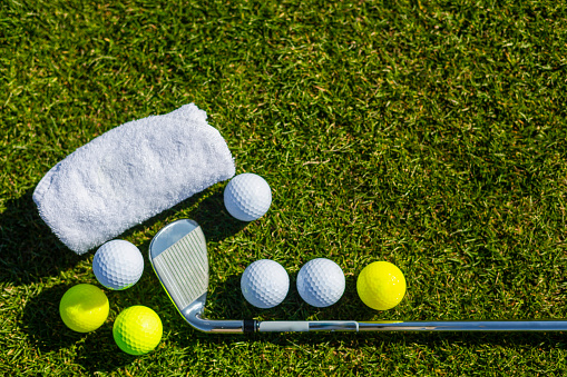 colorful golf balls, grass, towel.