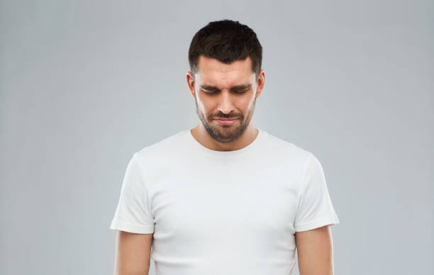 istock unhappy young man over gray background 1205501059