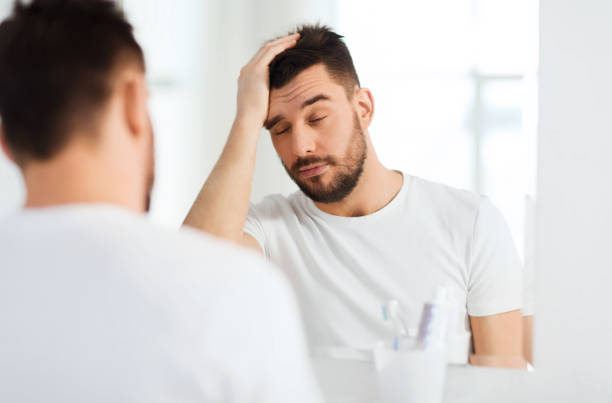 istock sleepy young man in front of mirror at bathroom 1205501212