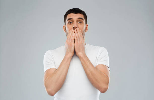 istock scared man in white t-shirt over gray background 1205501343