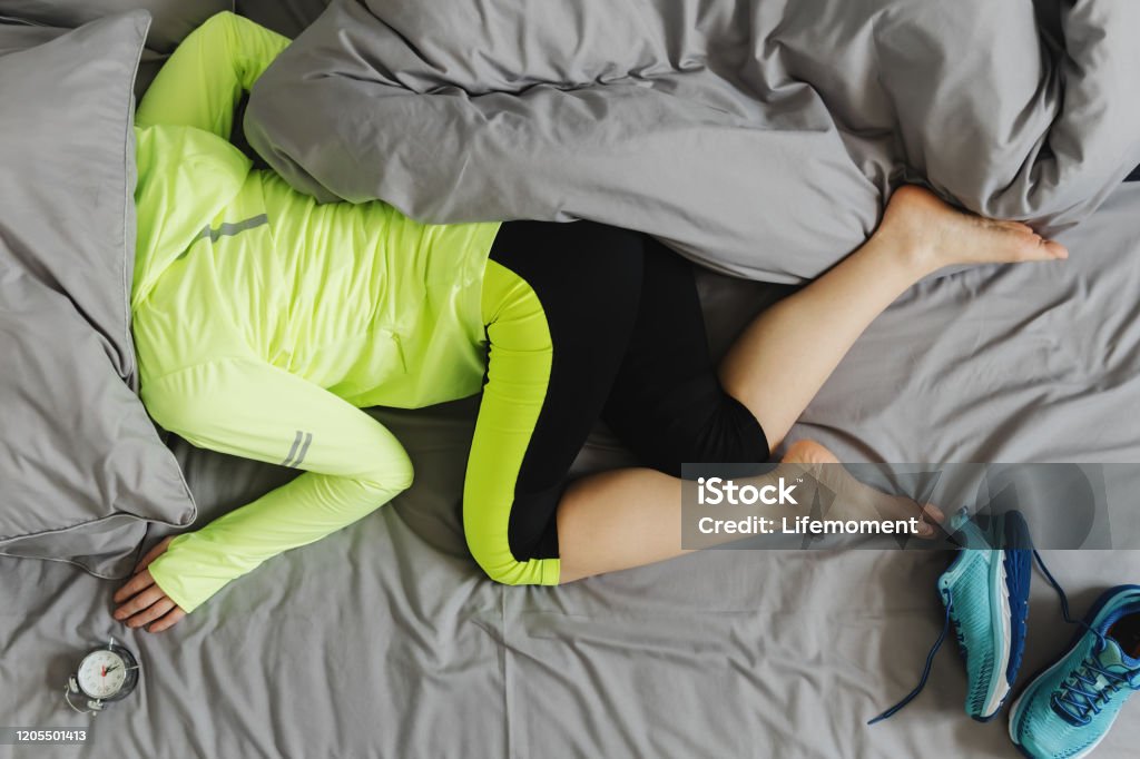 The concept the woman is too lazy to Wake up in the morning for training. The concept the woman is too lazy to Wake up in the morning for training. Sport concept. Sleeping Stock Photo