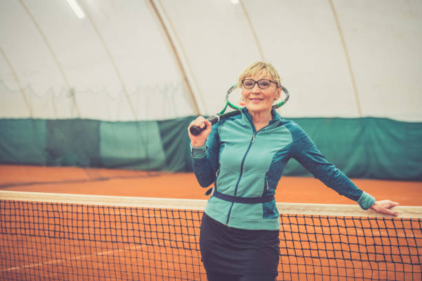 テニスの肖像画を演奏シニア女性 - indoor tennis ストックフォトと画像