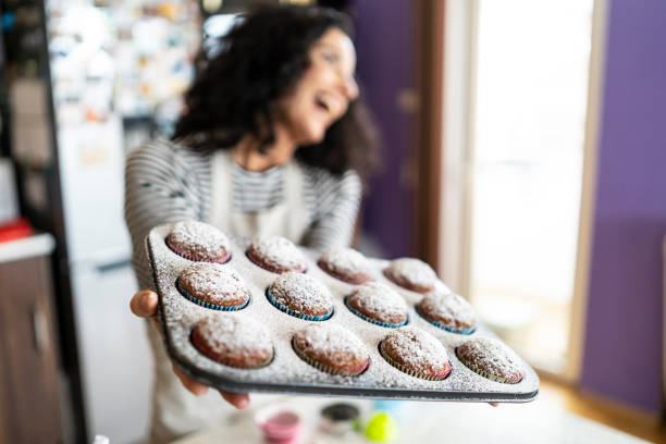 istock Smiling mother having fun with homemade muffins 1205502843