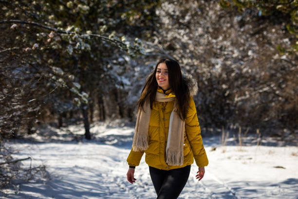 istock Smiling woman walking on snow in forest 1205503863