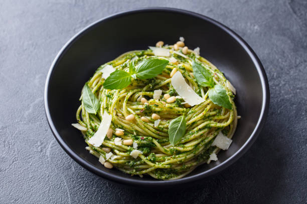 istock Pasta spaghetti with pesto sauce in black bowl. Grey background. Close up. 1205507241