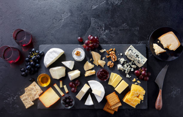istock Cheese assortment on slate cutting board with wine. Grey background. Top view. Copy space. 1205507565