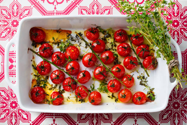 istock Roasted cherry tomatoes with herbs in baking dish. Top view. 1205507788