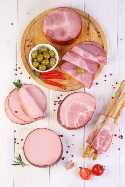 istock Assorted bacon, ham and olives on a white wooden table 1205507845