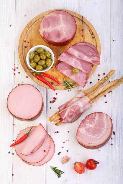 istock Assorted bacon, ham and olives on a white wooden table 1205507846