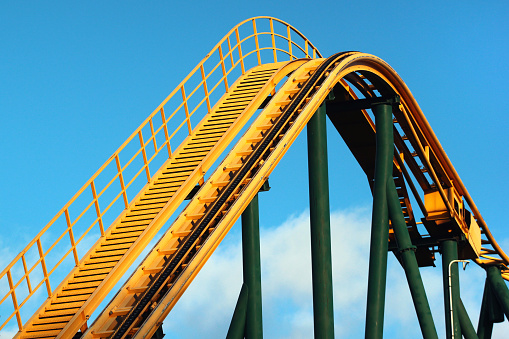 Roller coaster against blue sky background. Amusement park attractions.