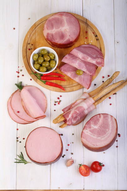 istock Assorted bacon, ham and olives on a white wooden table 1205509178
