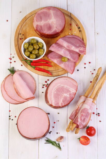 istock Assorted bacon, ham and olives on a white wooden table 1205509271