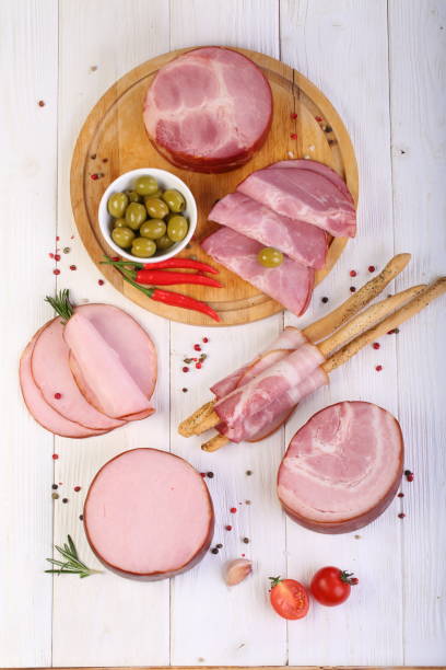 istock Assorted bacon, ham and olives on a white wooden table 1205509310