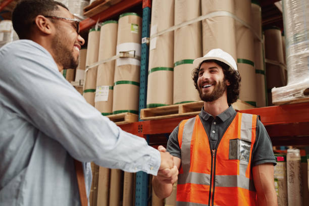istock Young partners congratulating each other on new business deal while standing in a modern factory 1205510143