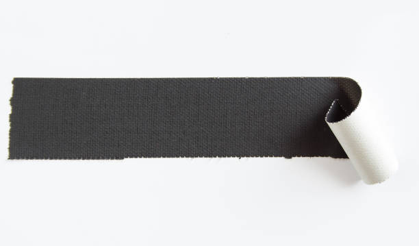 istock Peeling piece of black matte cloth gaffer tape isolated on white background. Space for text message. 1205510366