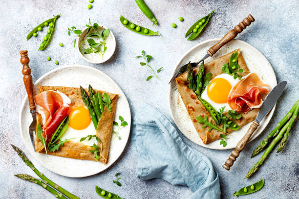Buckwheat crepes, galette bretonne with asparagus, egg, green pea, jambon or prosciutto. Galette sarrasin, french brittany cuisine stock photo