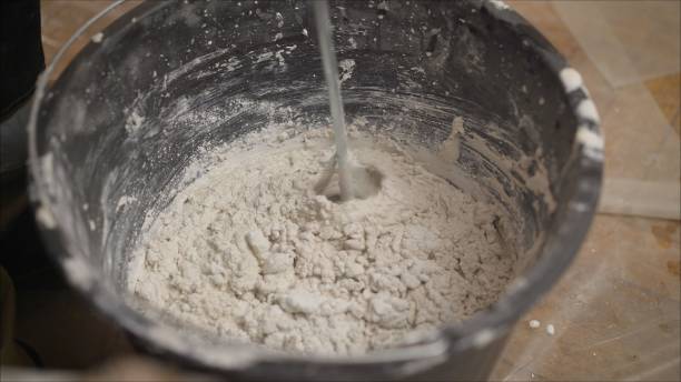 istock Builder mixing plaster in a bucket using an electric mixer. Builder mixes the mixture in a bucket using a construction mixer 1205512693