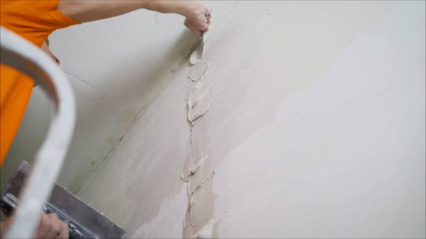 istock Plasterer putting plaster on wall. Worker covers the wall with mortar. 1205512712