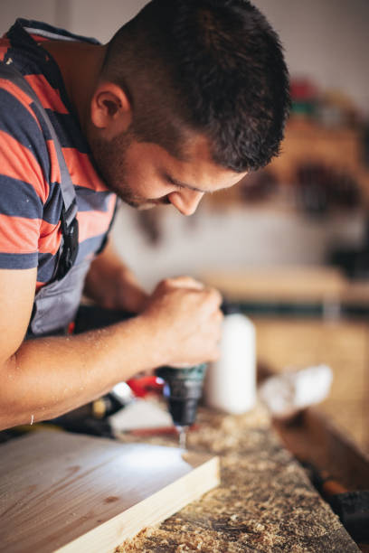 istock Young carpenter glueing wood 1205513677