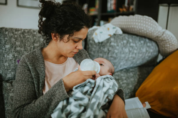 istock Mother Feeding Baby Boy While Sitting At Home 1205514172