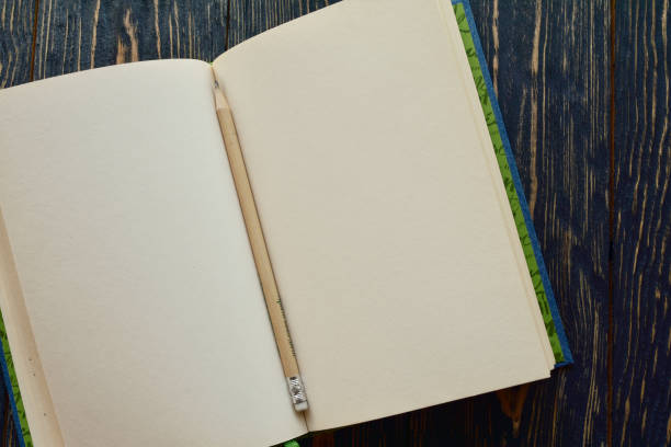 istock Open book with pencil on a dark wooden background. Top view. Close-up. Flat lay. 1205514392
