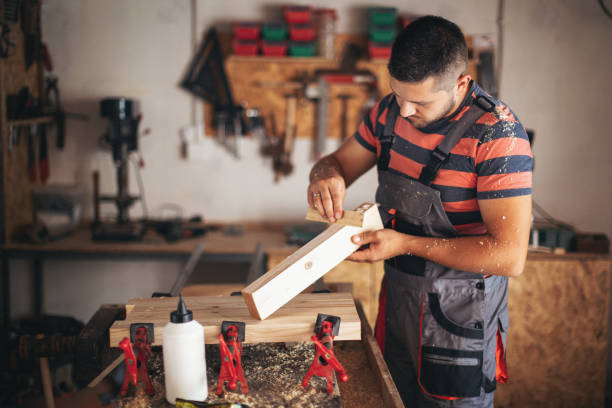 istock Young carpenter glueing wood 1205515631