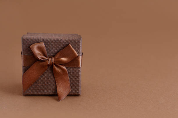 istock Brown gift box with a bow on a brown background 1205531825
