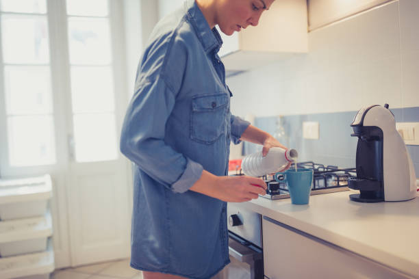 istock Young woman is making her morning coffee in her kitchen 1205533306