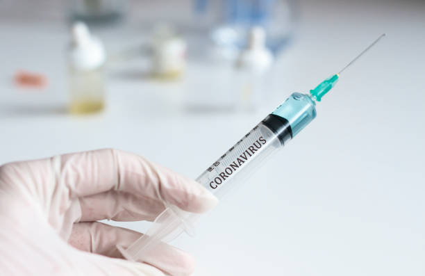 istock Docotor holding syringe with coronavirus test 1205534666