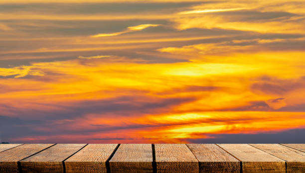 istock Empty display wooden board shelf table counter with copy space for advertising backdrop and background with orange sunset sky. 1205538109
