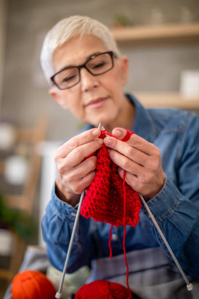 изготовление теплого шарфа на зиму - grandmother knitting senior women senior adult стоковые фото и изображения